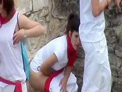 Uniformed gals pissing behind a car