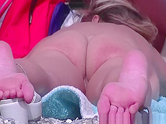 Nudist woman laid down on her stomach sunbathing