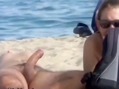 Wife strokes his half hard cock at the beach
