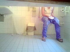 Girl in jeans makes water in the ladies room