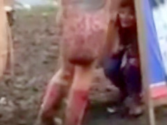 Hippie beauty peeing in the mud at concert