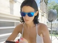 Sandy Yardish having a cigarette outside in swimsuit.